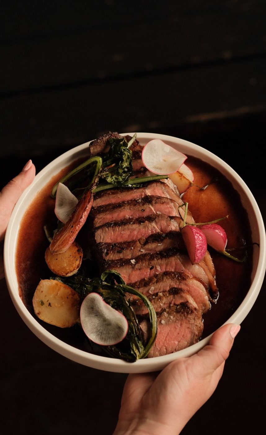 Sliced steak with roasted potatoes and radishes